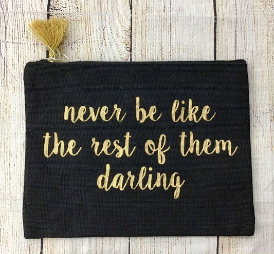 Mudpie Rest of Them Makeup BagBlack canvas makeup bag with gold print and gold tassel. Reads “Never be like  the rest of them darling”
